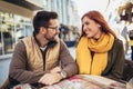 Young couple in love sitting at the cafe table outdoors Royalty Free Stock Photo