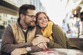 Young couple in love sitting at the cafe table outdoors Royalty Free Stock Photo