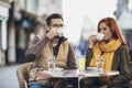 Young couple in love sitting at the cafe table outdoors, drinking coffee Royalty Free Stock Photo