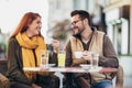 Young couple in love sitting at the cafe table outdoors, drinking coffee Royalty Free Stock Photo