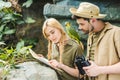 attractive young couple in safari suits with parrot trying to navigate