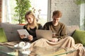 Attractive young couple using devices together, tablet, laptop, smartphone, headphones wireless. Gadgets and Royalty Free Stock Photo