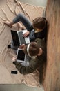 Attractive young couple using devices together, tablet, laptop, smartphone, headphones wireless. Gadgets and Royalty Free Stock Photo