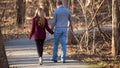 Attractive young couple walking away from viewer on path Royalty Free Stock Photo