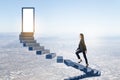 Attractive european business woman climbing sky stairs to success and opprtunity with open door and mock up place Royalty Free Stock Photo