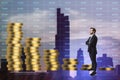 Attractive young european businessman with falling golden coins stack on blue index city background. Gold price concept. Double Royalty Free Stock Photo