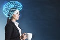 Attractive young european businesswoman with coffee cup and glowing digital brain hologram standing on blurry chalkboard wall