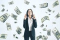 Attractive young european businesswoman with corssed fingers standing on white background with dollar banknote rain. Jackpot,