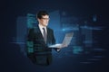 Attractive young european man with laptop standing on abstract blue background with coding and tech information. Database, cloud Royalty Free Stock Photo