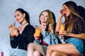 attractive young fashionable multiethnic women drinking cocktails