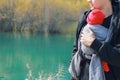 Attractive young father with her infant baby in sling outdoor. Man is carrying her child and travel in autumn mountain Royalty Free Stock Photo