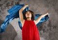 Attractive young female dancer with blue fabric and grey background. Royalty Free Stock Photo