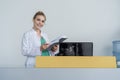 Attractive young female doctor leaning on the clinic reception desk, medical staff and healthcare concept. Royalty Free Stock Photo