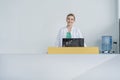 Attractive young female doctor leaning on the clinic reception desk, medical staff and healthcare concept. Royalty Free Stock Photo