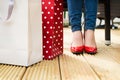 Attractive young female in red high heels enjoying a break after succesfull shopping