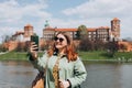 Attractive young female tourist is exploring new city. Redhead girl holding a smartphone in Krakow. Traveling. Happy Royalty Free Stock Photo