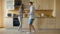 Attractive young funny couple have fun dancing while cooking in the kitchen at home Royalty Free Stock Photo