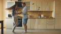Attractive young funny couple have fun dancing while cooking in the kitchen at home Royalty Free Stock Photo