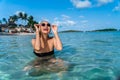 Attractive young girl is bathing on the beach in clear turquoise sea water and laughing merrily. Portrait of a young girl in the Royalty Free Stock Photo