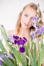 Attractive young girl with blond curly hair and beautiful make-up in a delicate blond chiffon blouse with blue irises