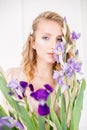 Attractive young girl with blond curly hair and beautiful make-up in a delicate blond chiffon blouse with blue irises