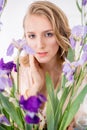 Attractive young girl with blond curly hair and beautiful make-up in a delicate blond chiffon blouse with blue irises