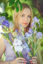 Atraktivní mladý blondýnka vlasy přírodní vonící modrý purpurová kosatec květiny na venku nabídka 