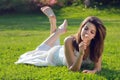 Attractive young girl with daisy lying on grass Royalty Free Stock Photo