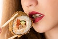 Attractive young girl eating sushi roll, closeup mouth