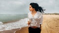 Attractive young girl enjoys walk along beach with glass of wine. Vacation, hiking, hiking concept