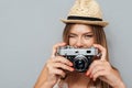 Attractive young girl in hat winking and holding camera