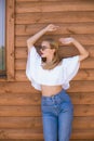 Attractive young girl with a perfect figure and blond hair in trendy jeans and a white top with ruffles and sunglasses Royalty Free Stock Photo