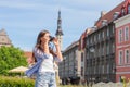 Attractive young girl traveling and exploring beautiful old town. Tourist with a retro camera on a vacation. Royalty Free Stock Photo