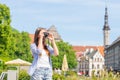 Attractive young girl traveling and exploring beautiful old town. Tourist with a retro camera on a vacation. Royalty Free Stock Photo