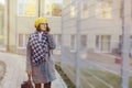 An attractive young girl wearing sunglasses in a coat walking down the street and talking on the phone and smiles Royalty Free Stock Photo