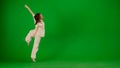 Attractive young girl in white outfit dancing showing modern contemporary dance on chroma key green screen background. Royalty Free Stock Photo