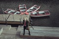 An attractive young guy in a khaki military cloak stands on a boat pier river boat station Royalty Free Stock Photo