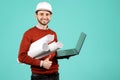 Attractive young handsome bearded engineer or constructor man in casual outfit holding notebook or computer over cyan Royalty Free Stock Photo