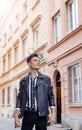 Attractive young hipster man in black jacket. fashionable walks in the city. Urban fresh portrait confident young man