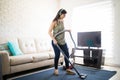 Musical young woman enjoying music on headphones and cleaning ca