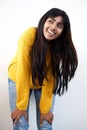 Attractive young Indian woman smiling with hands on knee against white background Royalty Free Stock Photo