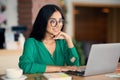 Attractive indian woman studying online at cafe, using laptop Royalty Free Stock Photo