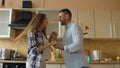 Attractive young funny couple have fun dancing while cooking in the kitchen at home Royalty Free Stock Photo