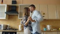 Attractive young funny couple have fun dancing while cooking in the kitchen at home Royalty Free Stock Photo