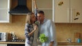 Attractive young joyful couple have fun dancing and singing while cooking in the kitchen at home Royalty Free Stock Photo