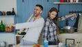 Young joyful couple have fun dancing and singing while set the table for breakfast in the kitchen at home Royalty Free Stock Photo