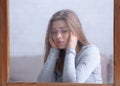 Attractive young lady feeling unhappy because of bad weather, looking out window with rain drops, lost in thought Royalty Free Stock Photo