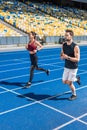 attractive young male and female joggers running on track Royalty Free Stock Photo