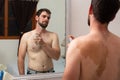 attractive young man applying perfume using fragrance on body, young man with diverse skin stain or mole, i feel so happy in my Royalty Free Stock Photo