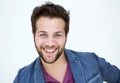 Attractive young man with beard smiling on white background